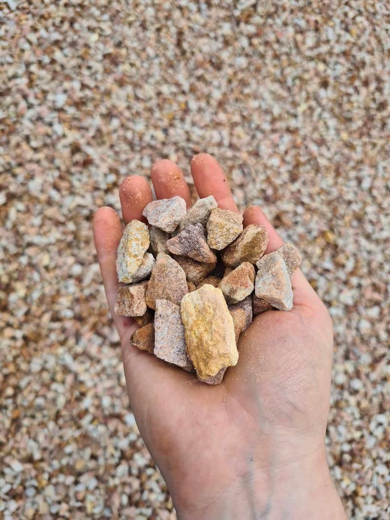 A Hand holding Standstone rocks — Campbell's Truck and Bobcat and Landscape Supplies In Gympie, QLD