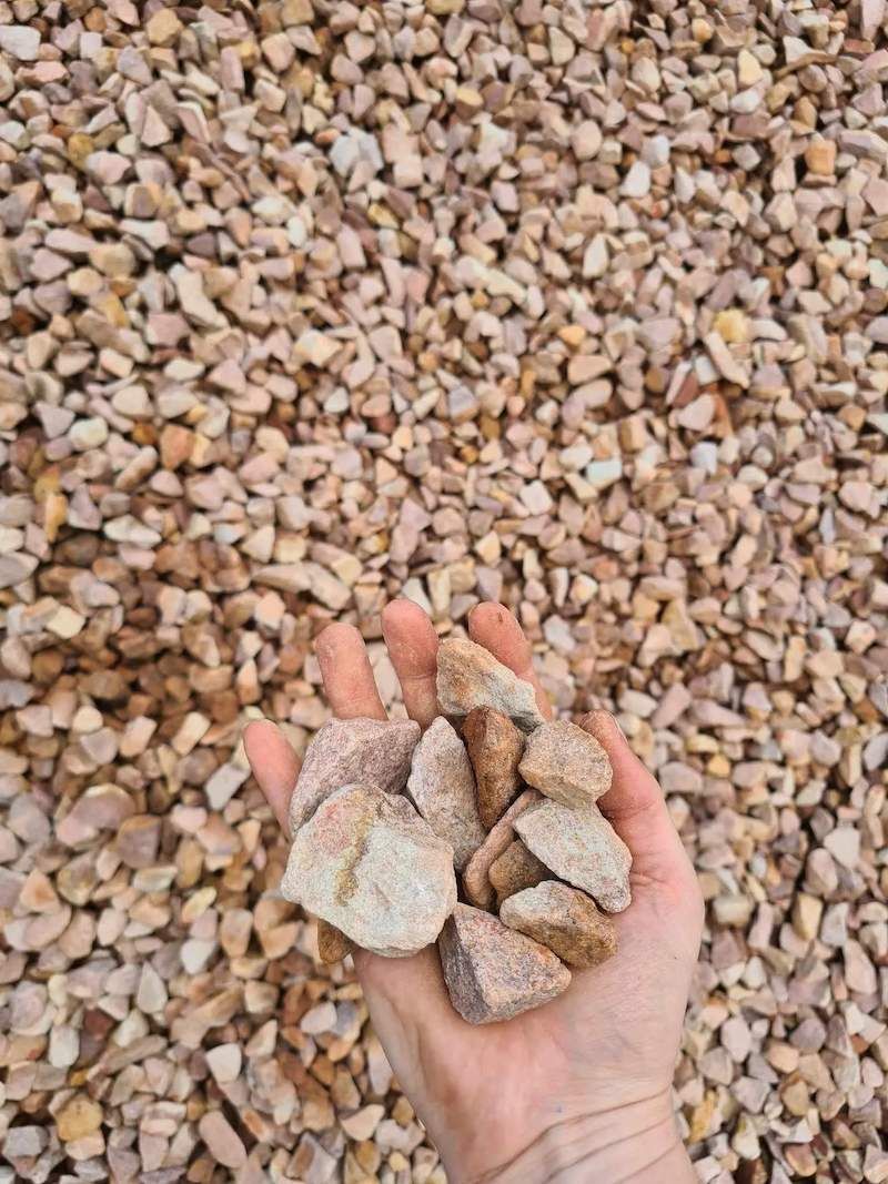 A Person Is Holding A Pile Of Gravel In Their Hand — Campbell's Truck and Bobcat and Landscape Supplies In Gympie, QLD