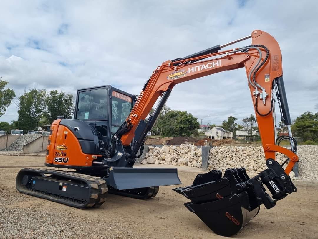 A Yellow Excavator is Sitting on Top of a Dirt Field — Campbell's Truck and Bobcat and Landscape Supplies In Gympie, QLD