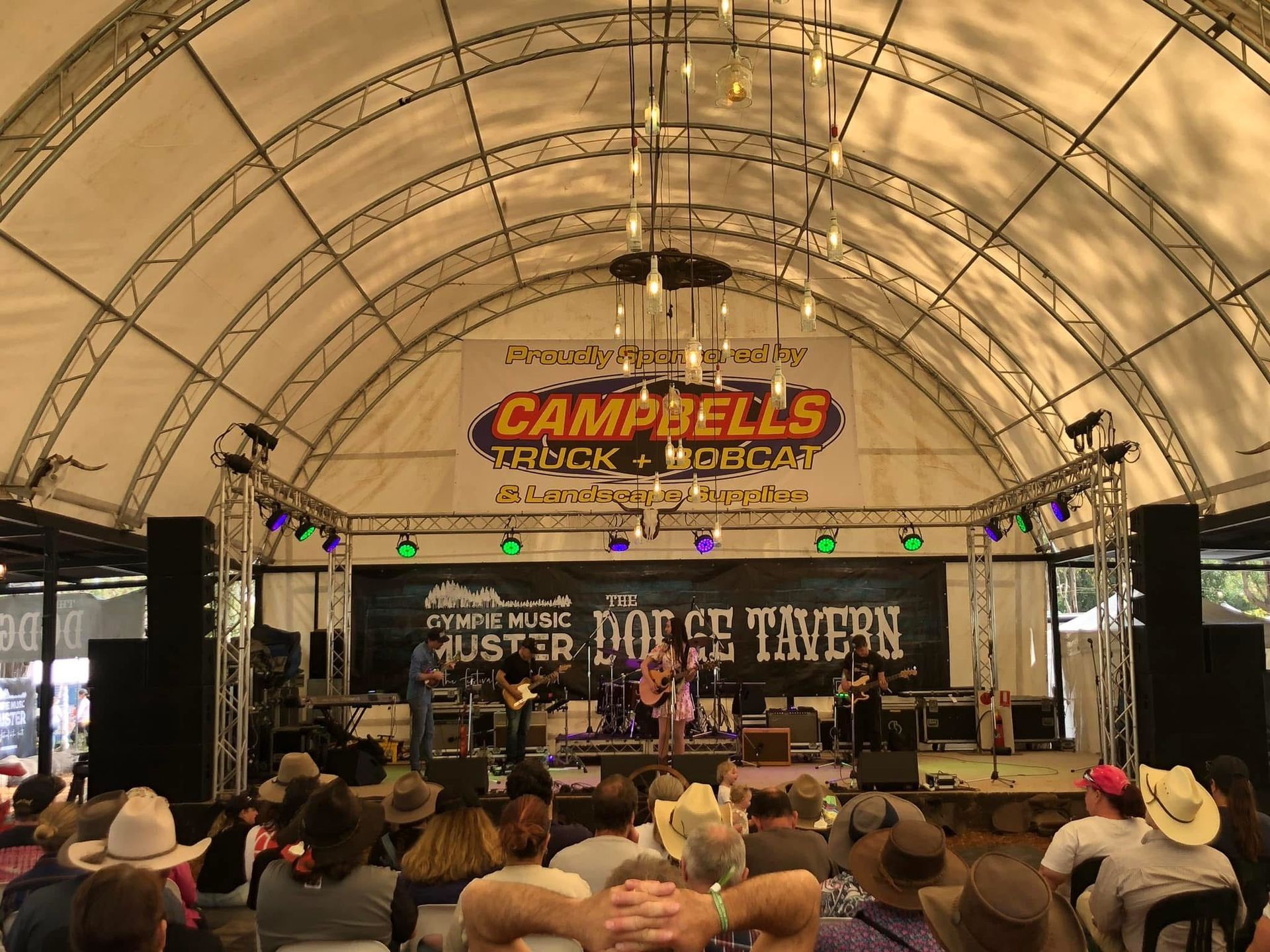 A white dump truck is parked in a dirt lot.