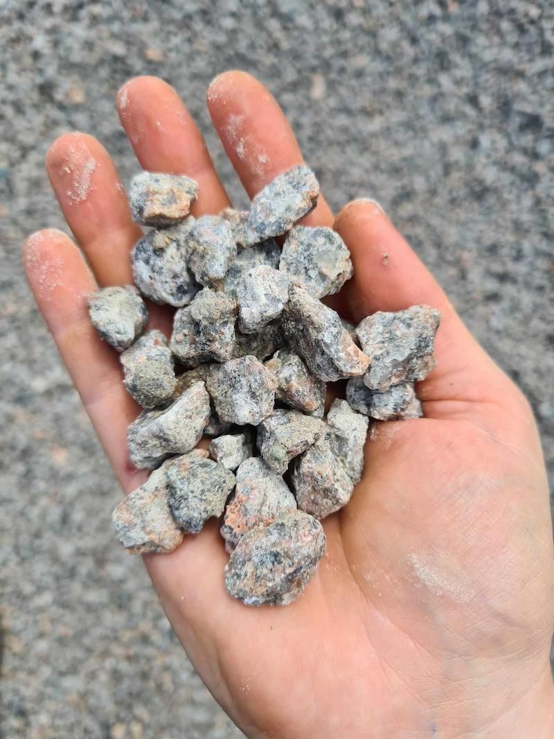 A Person Is Holding A Pile Of Rocks In Their Hand — Campbell's Truck and Bobcat and Landscape Supplies In Gympie, QLD