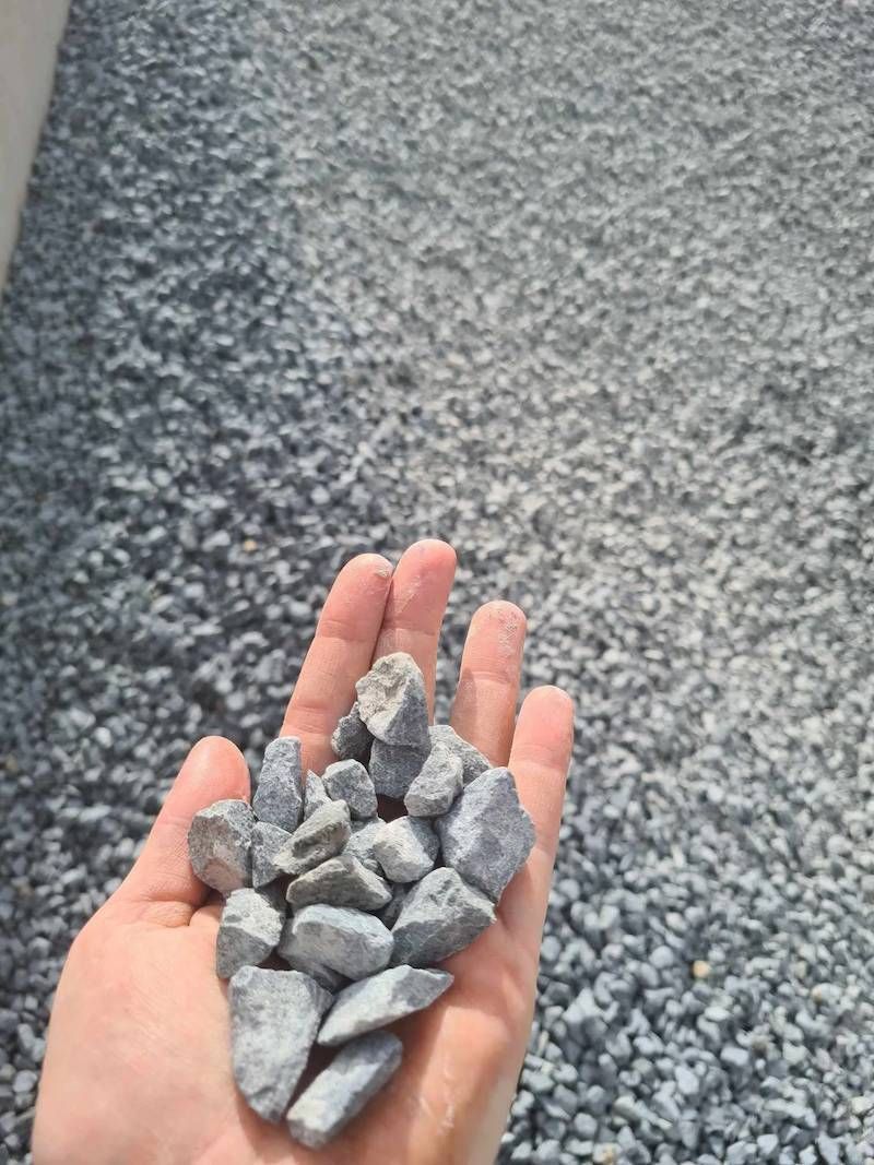A Person Is Holding A Pile Of Big Gravel In Their Hand — Campbell's Truck and Bobcat and Landscape Supplies In Gympie, QLD