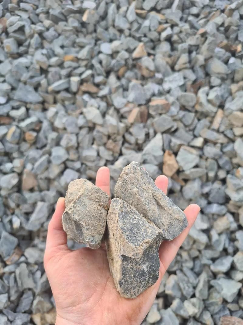 A Person Is Holding Three Pieces Of Big Rocks — Campbell's Truck and Bobcat and Landscape Supplies In Gympie, QLD