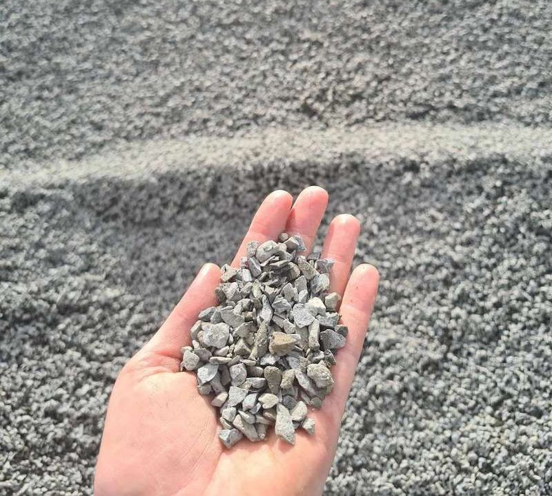 A Person is Holding a Pile of Rocks in Their Hand — Campbell's Truck and Bobcat and Landscape Supplies In Gympie, QLD