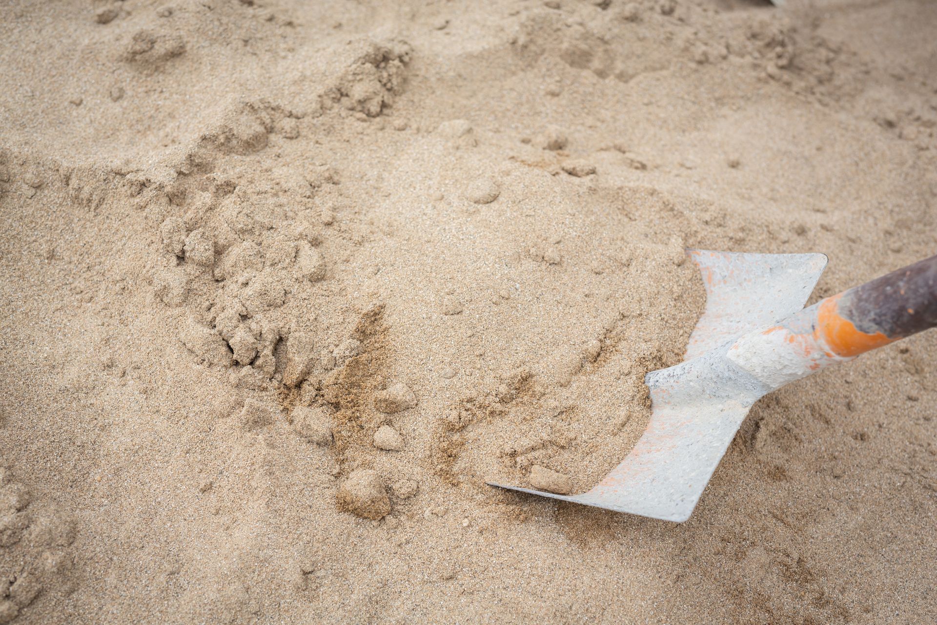 A Spade is Picking up a Pile of Sand — Campbell's Truck and Bobcat and Landscape Supplies In Gympie, QLD
