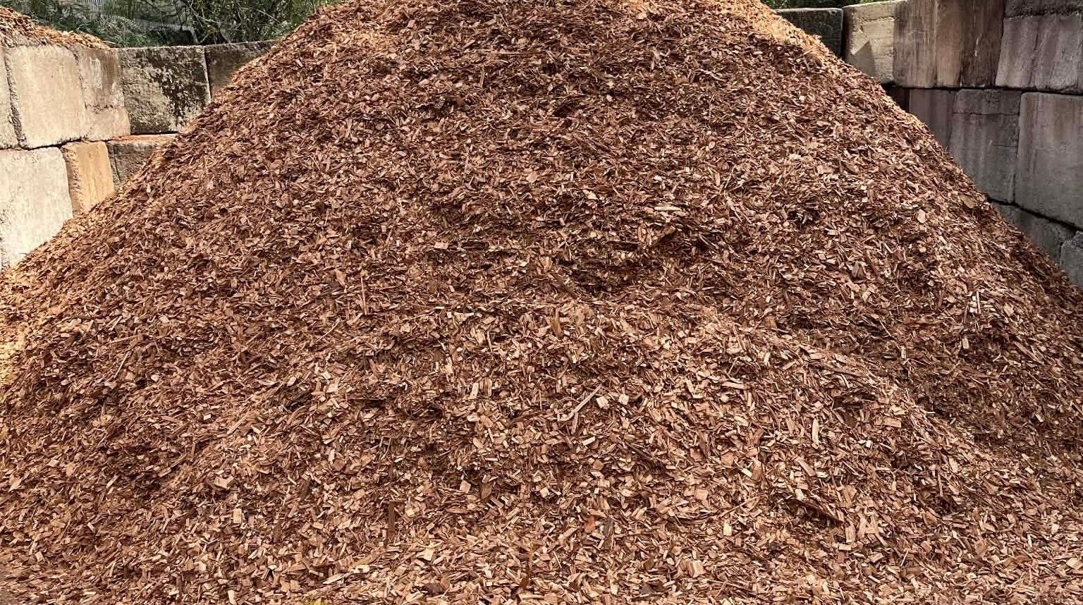 Pile of brown wood chips against a background of stacked blocks.
