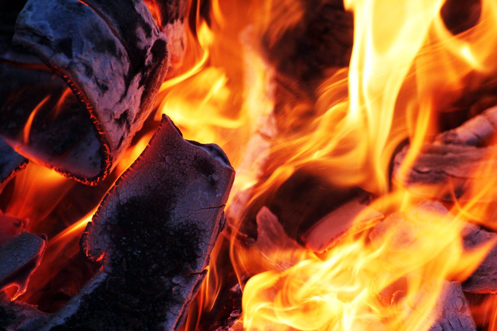 Burning wood fire with orange and yellow flames, with 