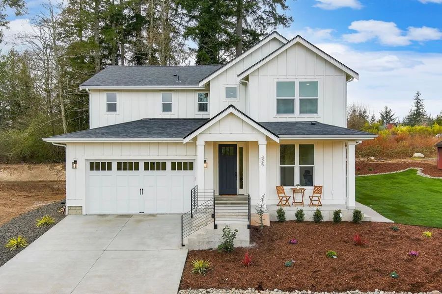 A white house with a black roof and a porch