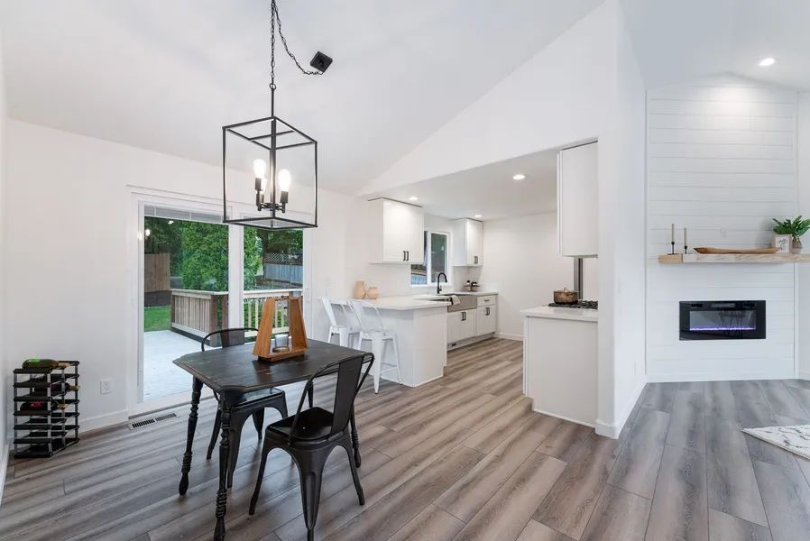A dining room with a table and chairs and a fireplace.