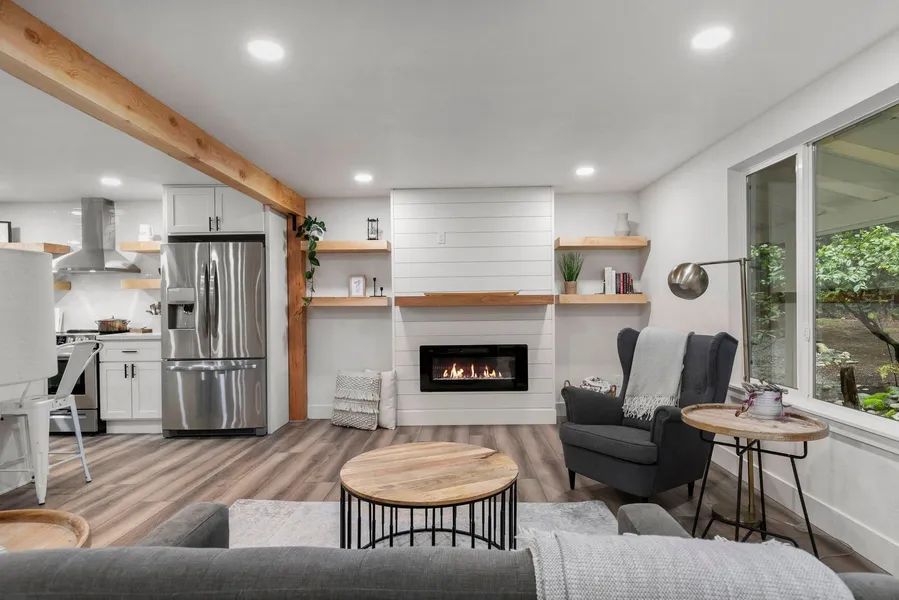 A living room with a couch , chair , table and fireplace.
