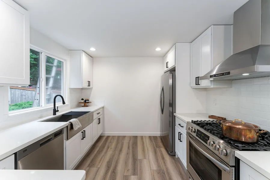 A kitchen with white cabinets and stainless steel appliances.
