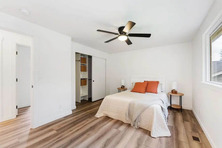 A bedroom with a bed and a ceiling fan.