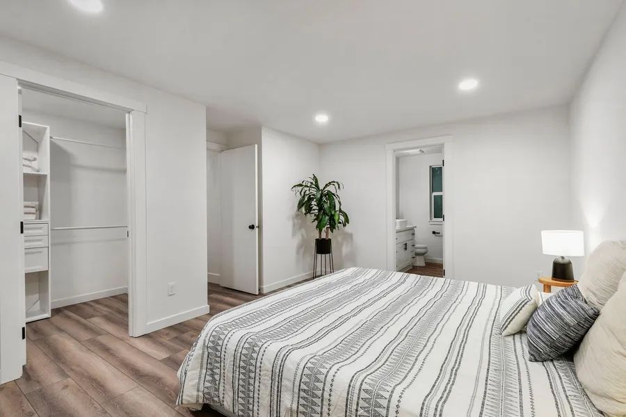 A bedroom with a large bed and a walk in closet.