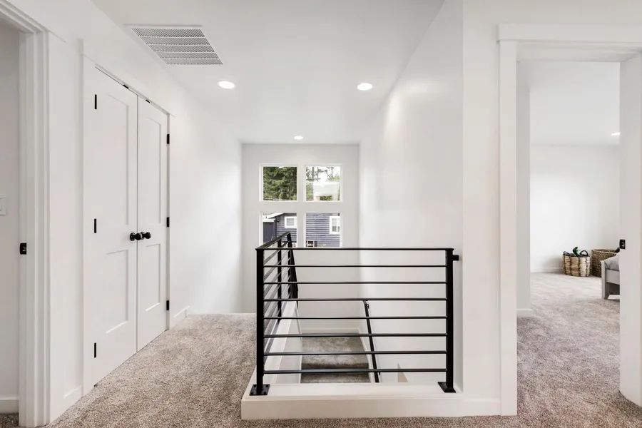 A hallway with a staircase leading up to the second floor of a house.