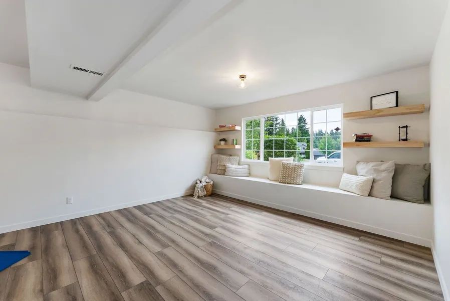 A living room with hardwood floors and a window seat.
