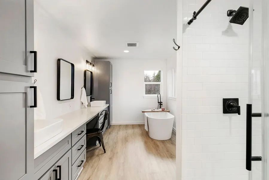 A bathroom with a tub , sink , and shower.