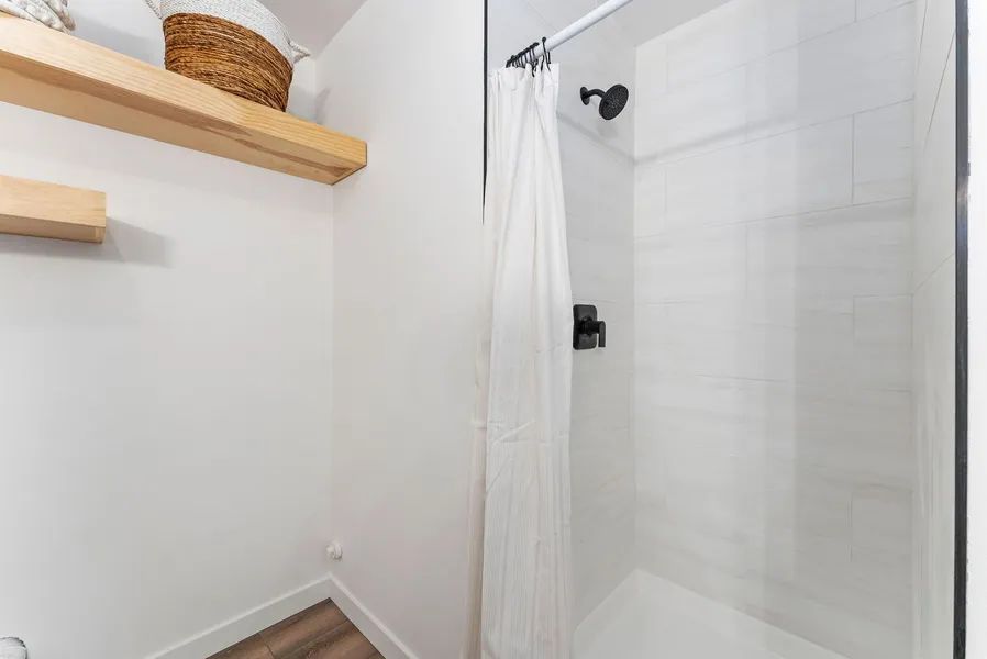 A bathroom with a shower curtain and a glass shower door.