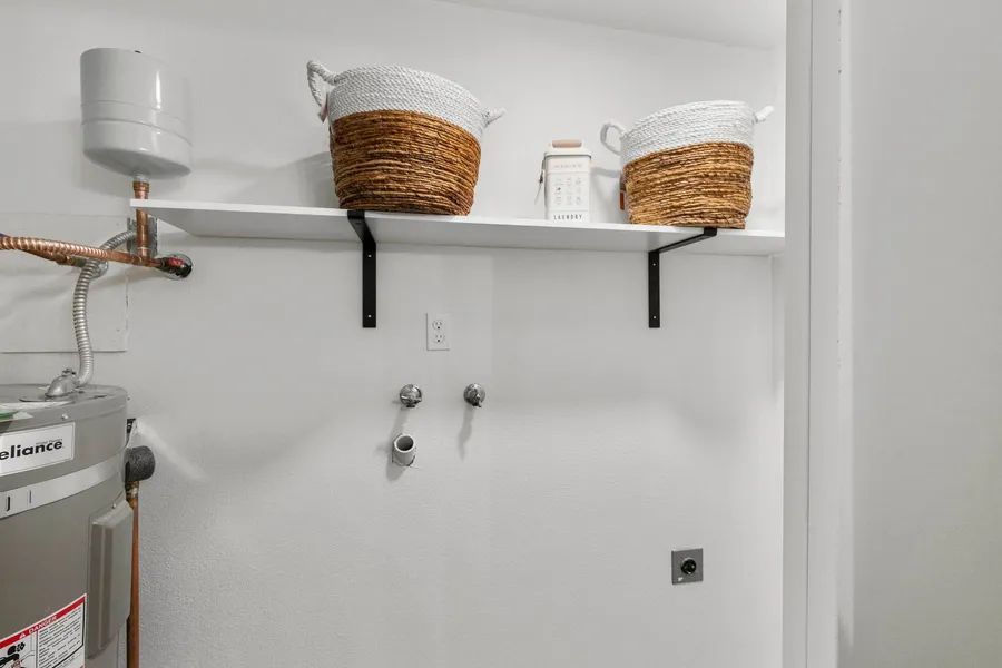 A laundry room with a shelf and baskets on it.