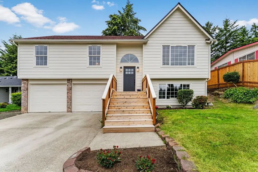 A large white house with stairs leading up to the front door.