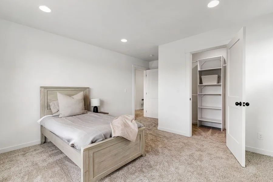 A bedroom with a bed , closet , and carpet.