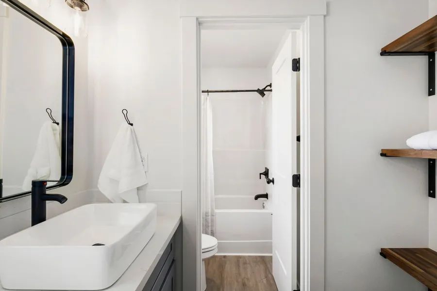 A bathroom with a sink , mirror , and bathtub.