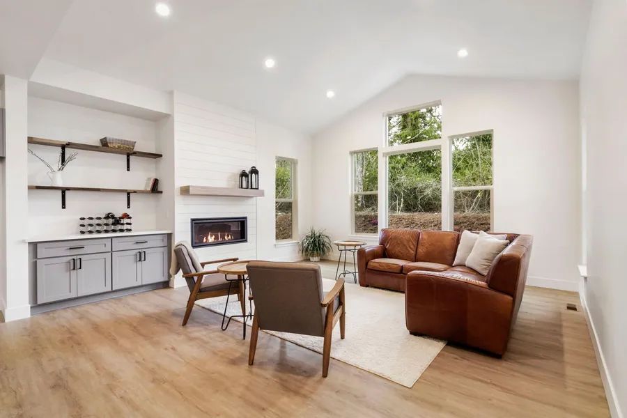 A living room with a couch , chairs , and a fireplace.