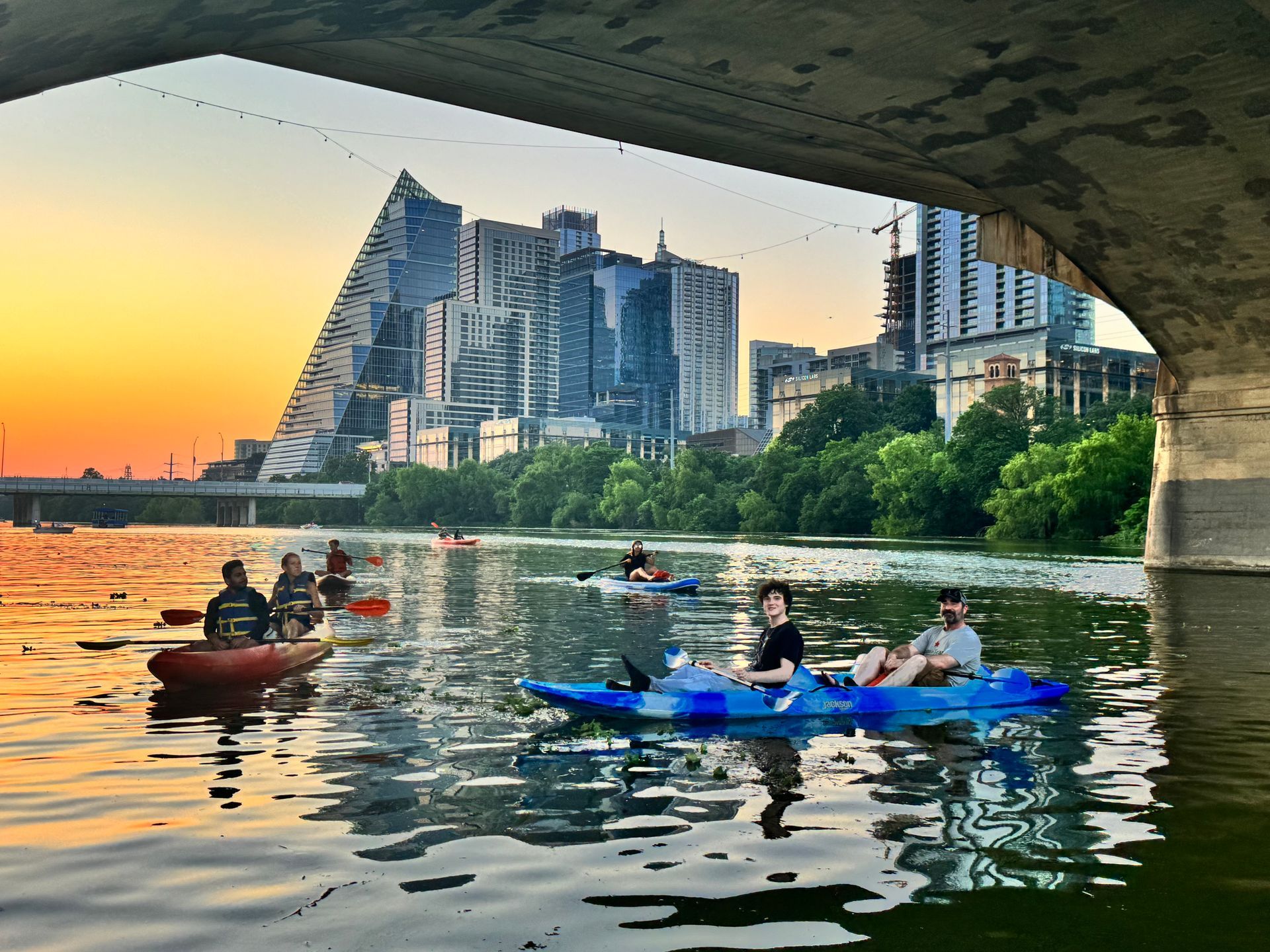Paddleboarders on Lady Bird Lake with Austin skyline on at sunset