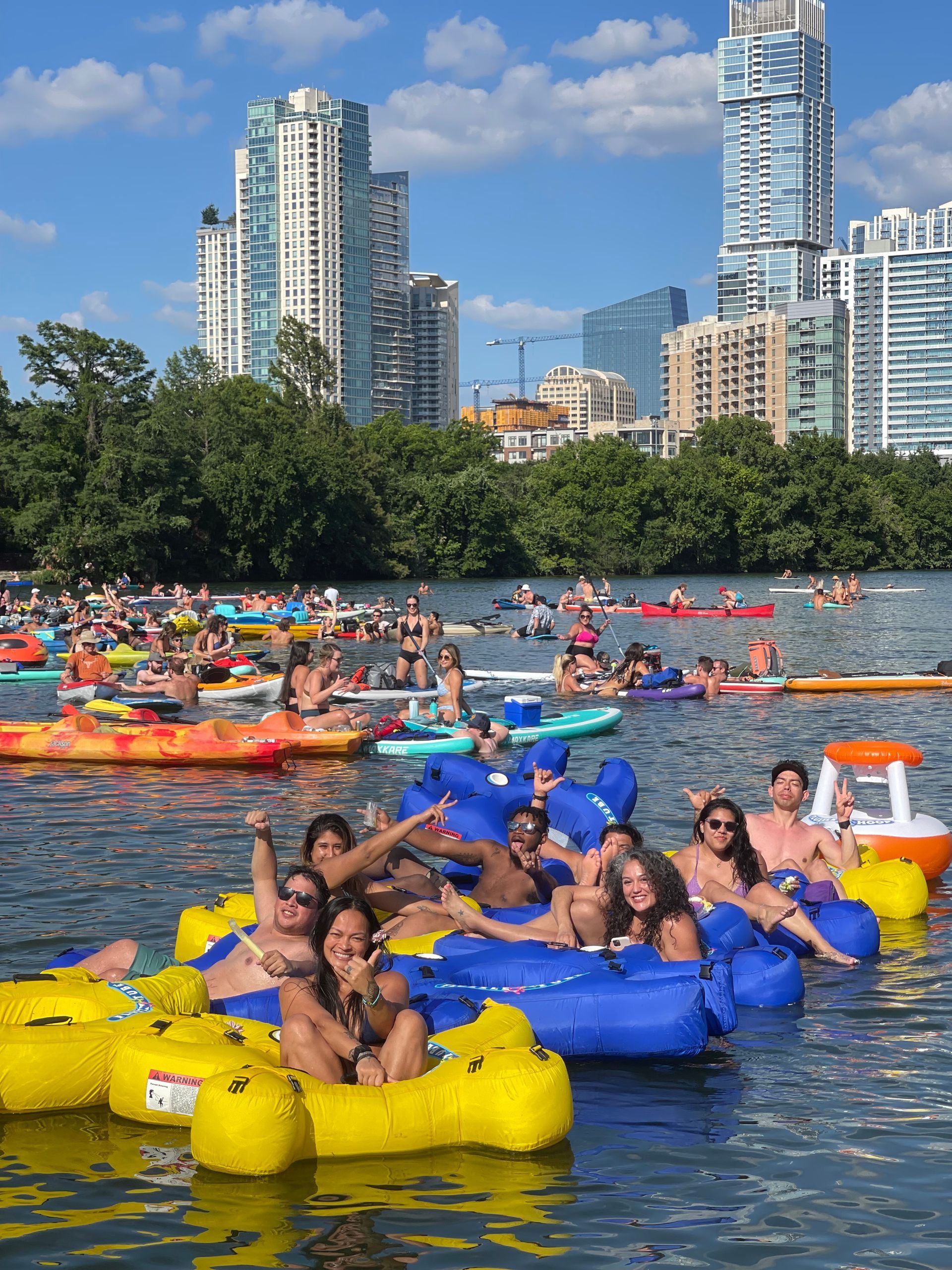 Group tubing on Lady Bird Lake with the Austin skyline in view in the summer