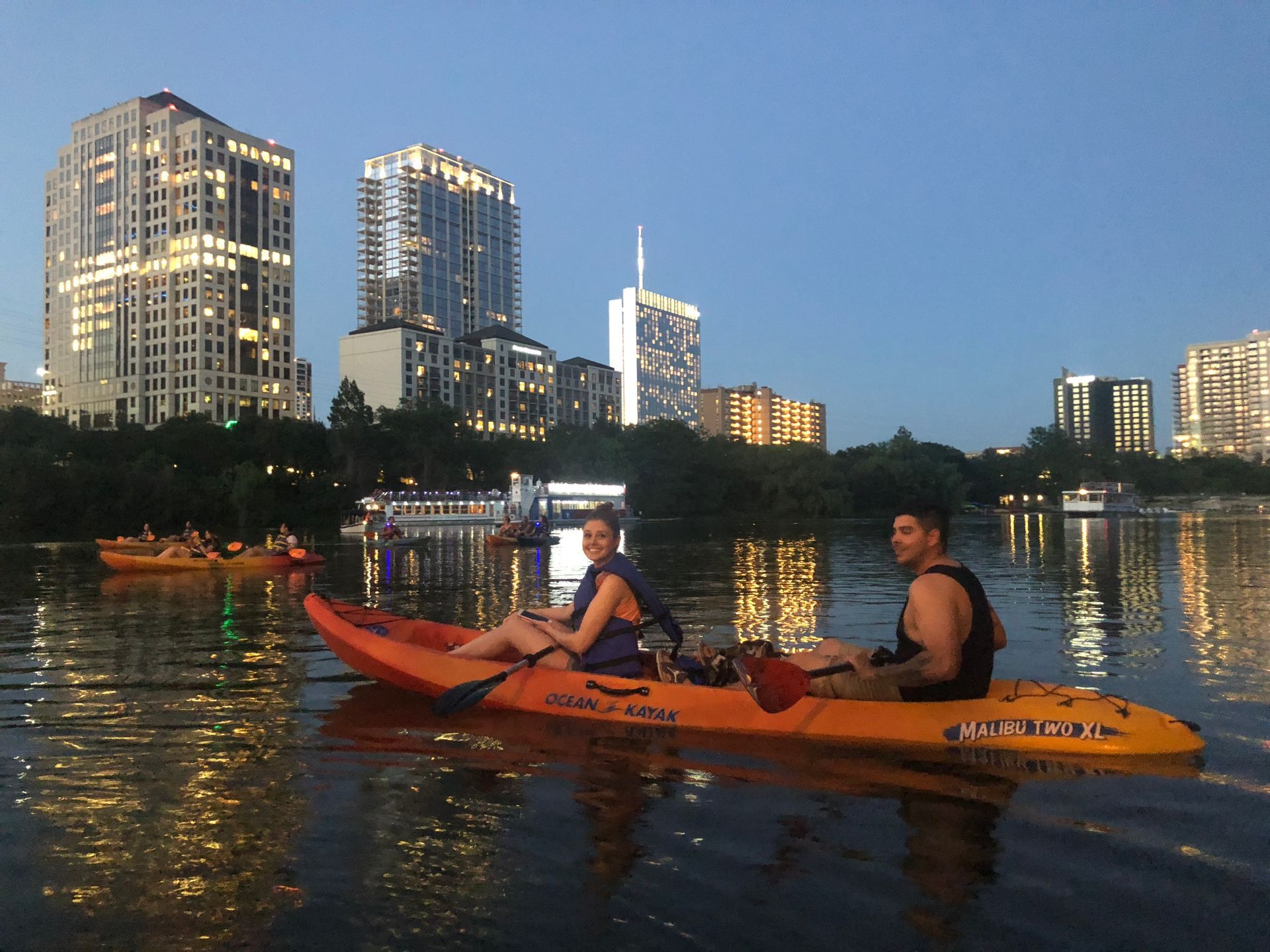 Paddleboarders on Lady Bird Lake watching the bats emerge at sunset.