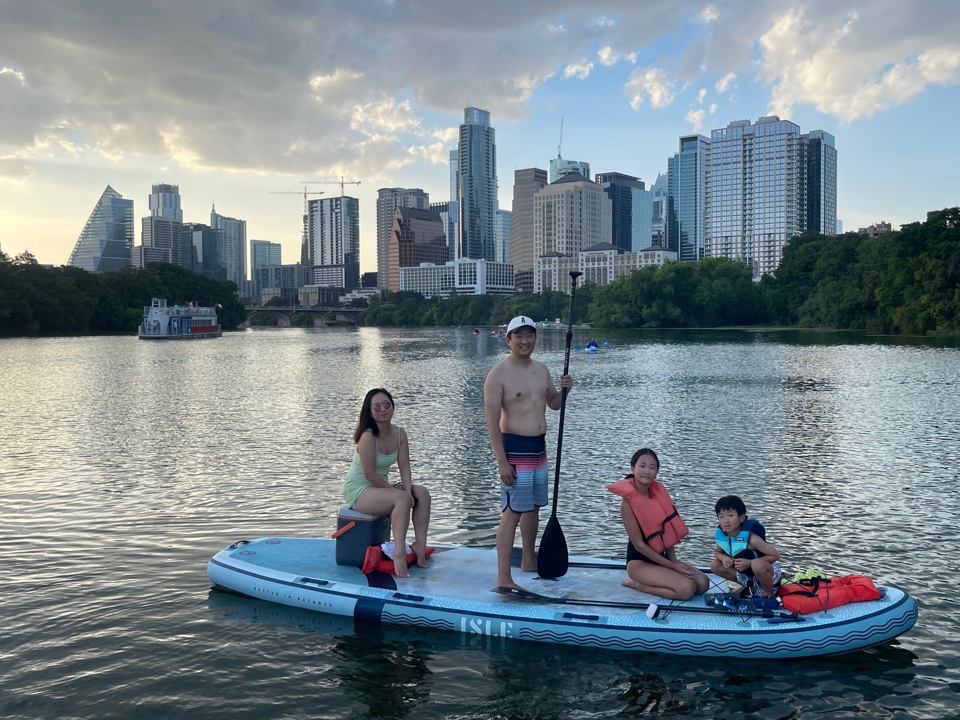 People paddleboarding on Lady Bird Lake with the Austin skyline in the background.