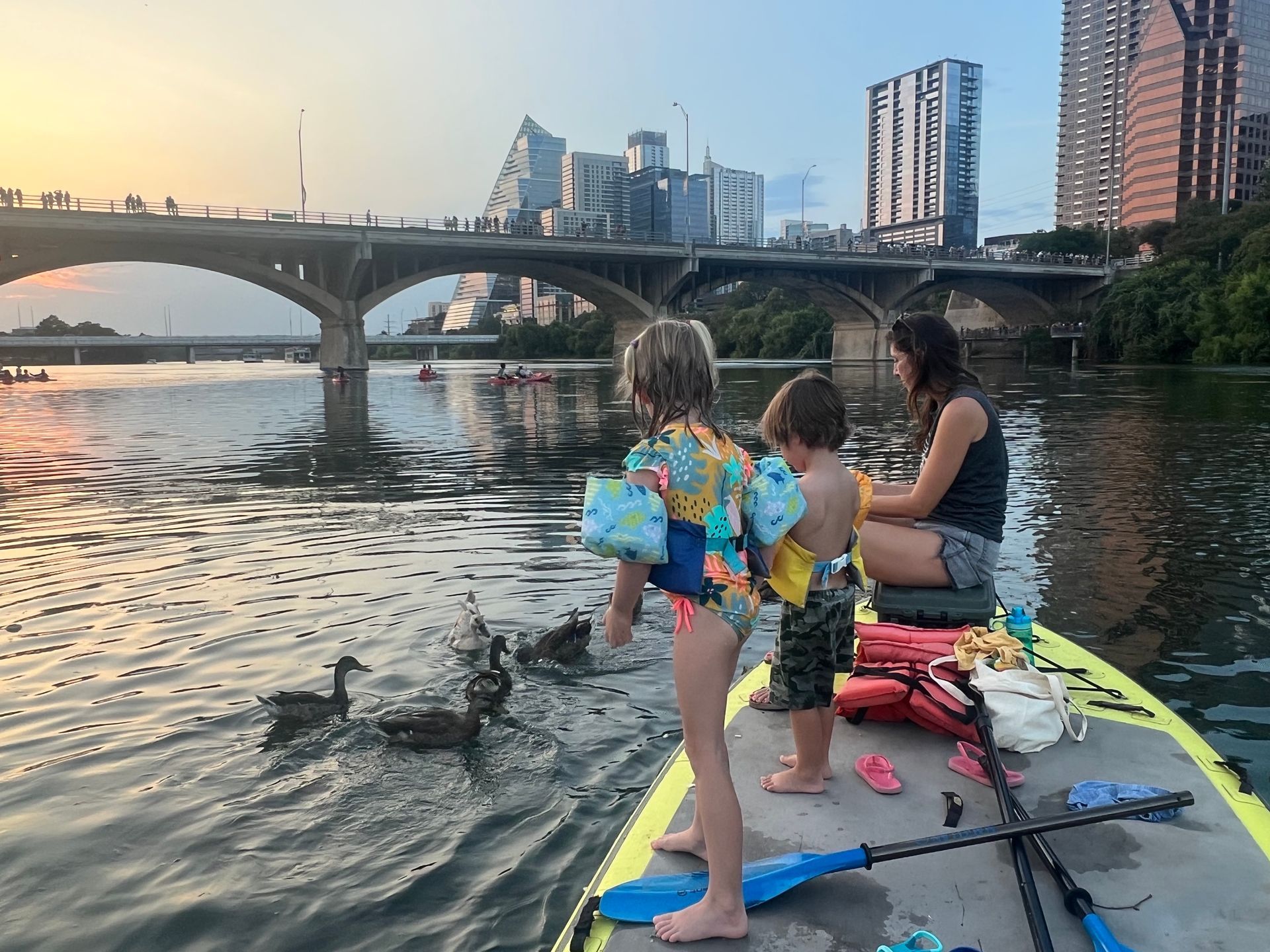 Family enjoying paddleboarding together on Lady Bird Lake.