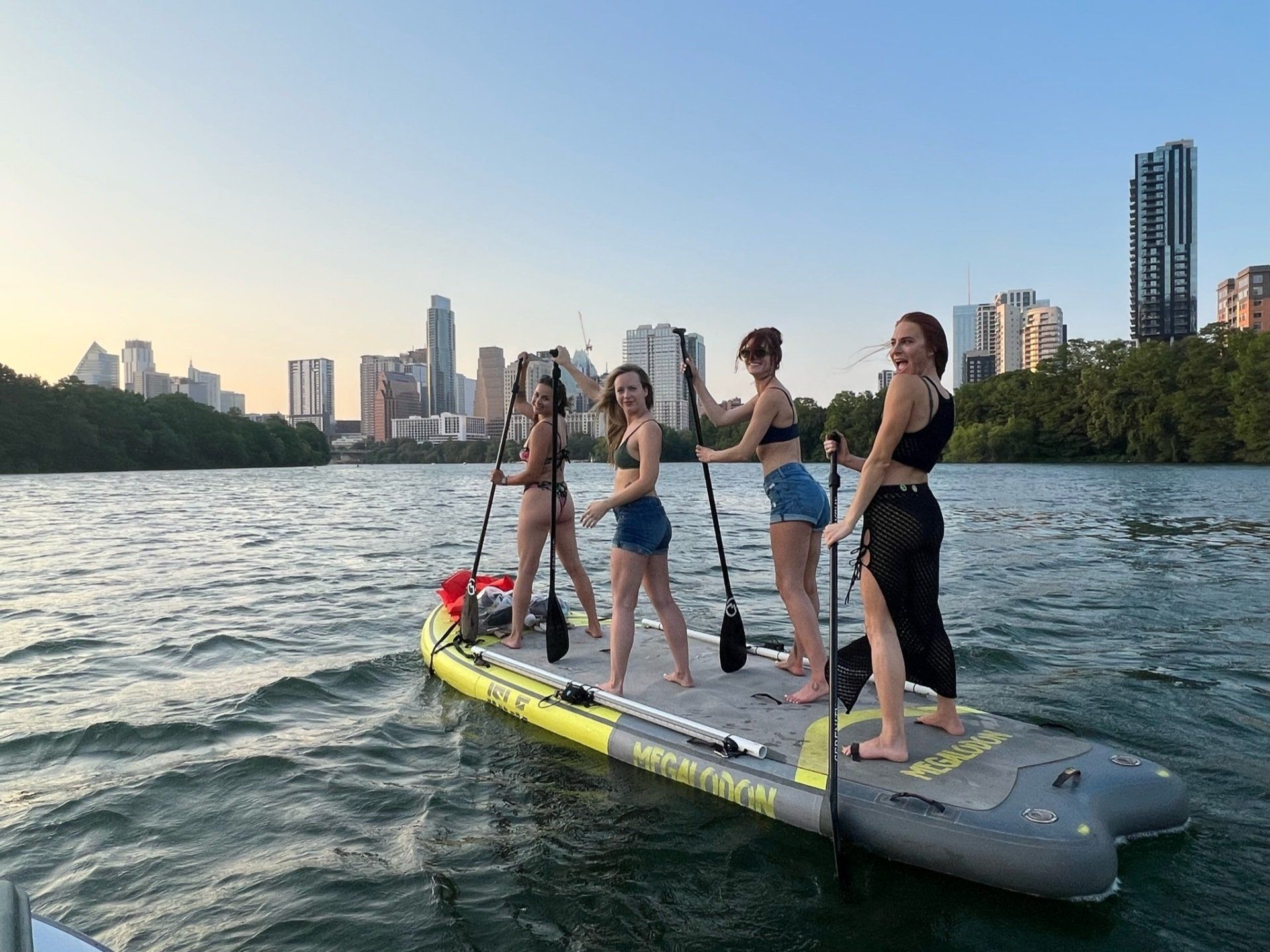 4 girls on a giant paddle board with boats and bats tour in austin