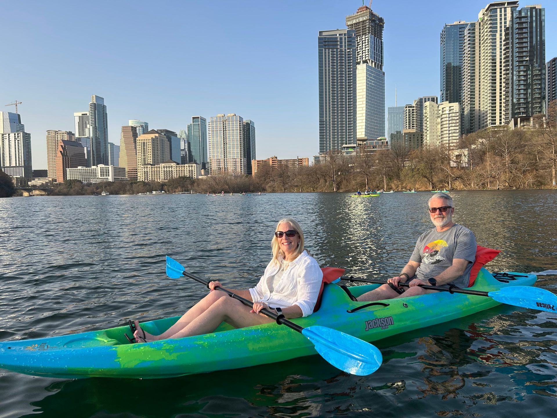Kayakers paddling on Lady Bird Lake with Austin skyline in background