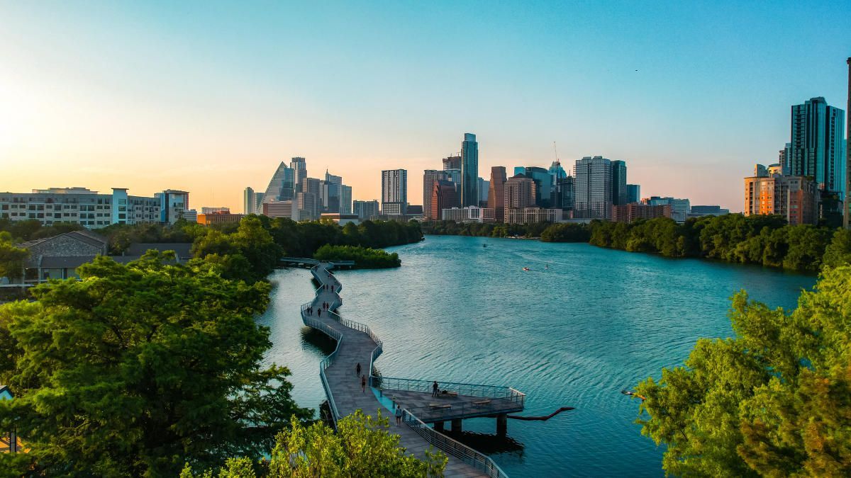 Scenic view of Lady Bird Lake with people jogging and biking along the trail.