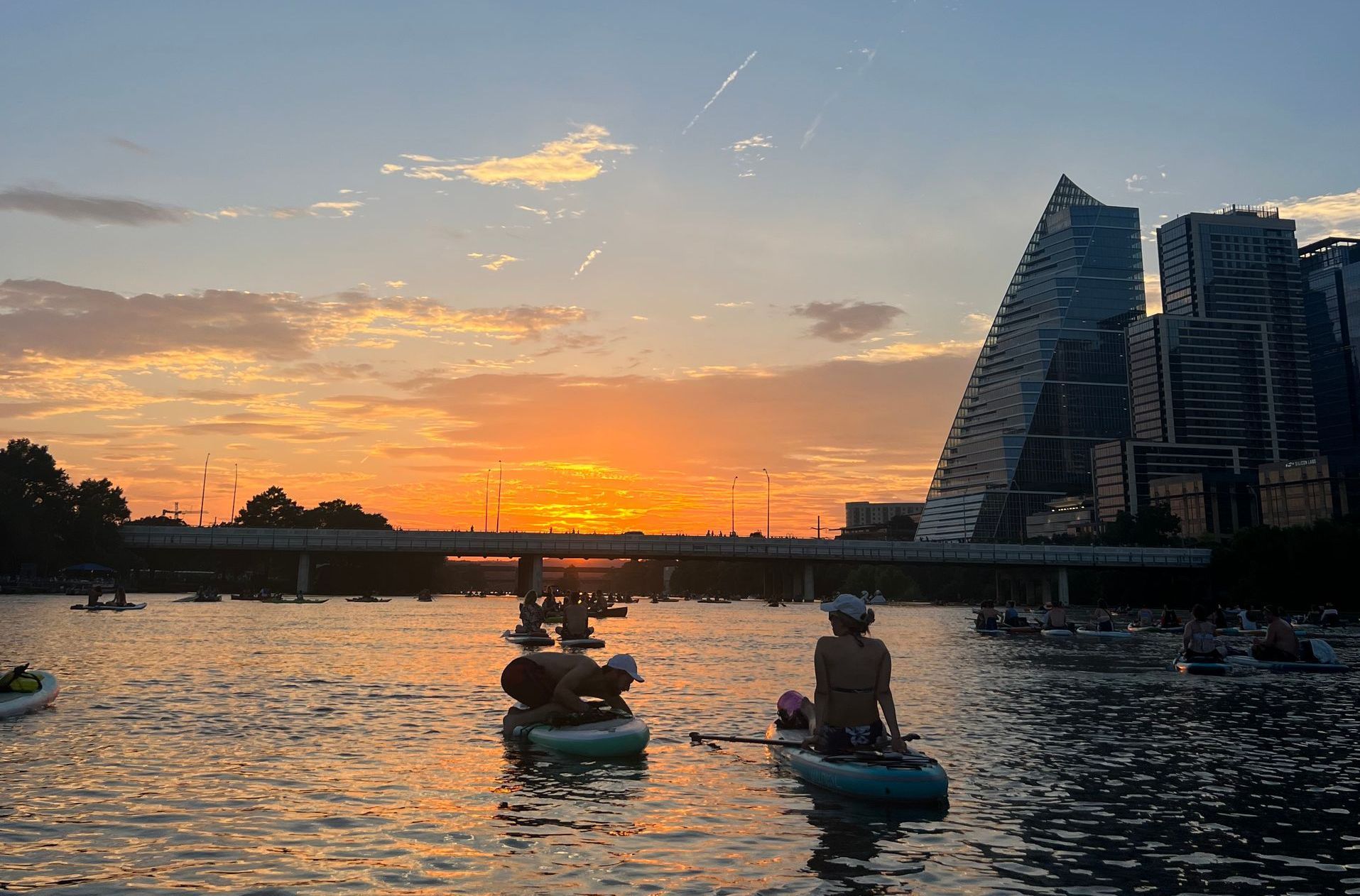 Sunset over Boats and Bats kayakers on Lady Bird Lake in Austin Texas