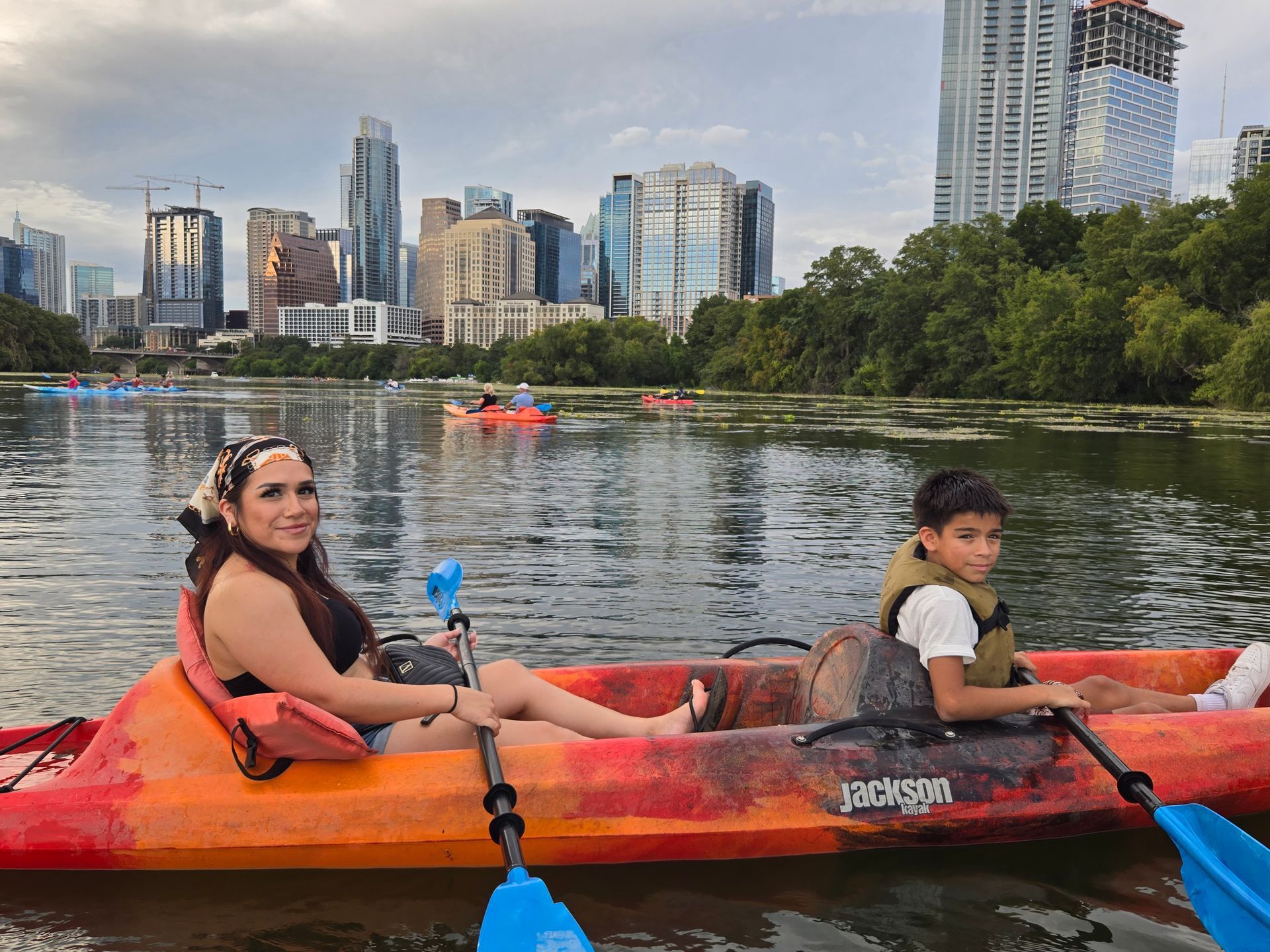 Group kayaking on Lady Bird Lake in activewear during sunset