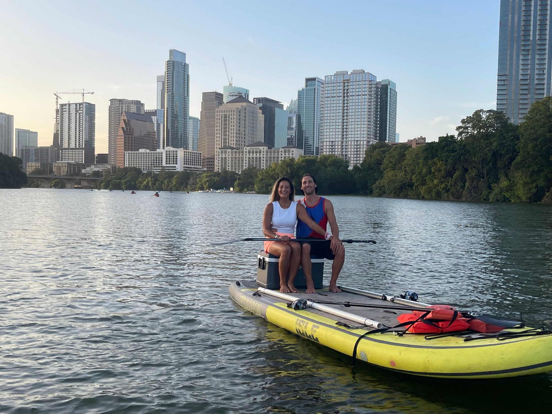 Two paddleboarders on Lady Bird Lake during a peaceful sunset