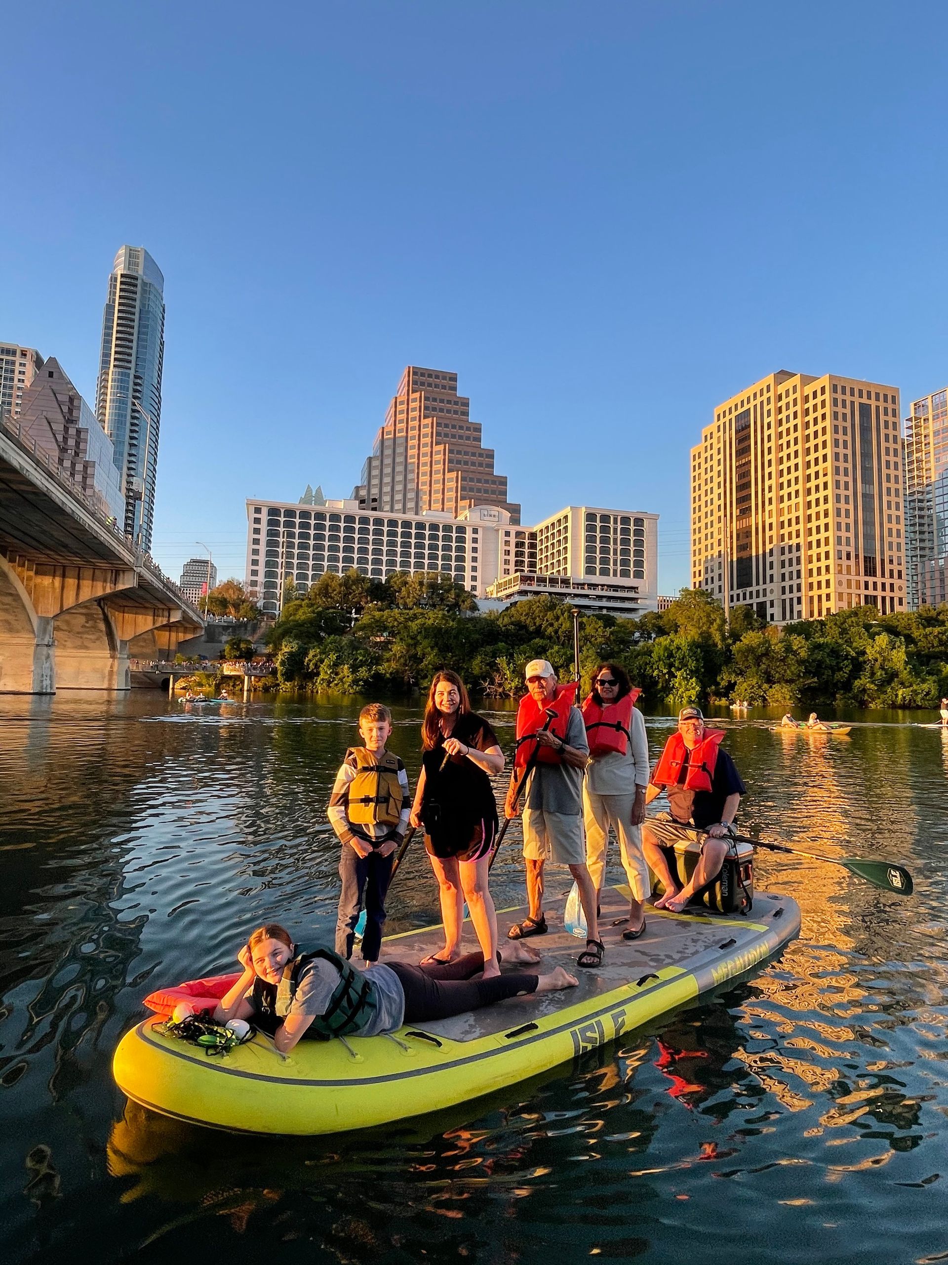 a group of people kayaking under Austin skyline during