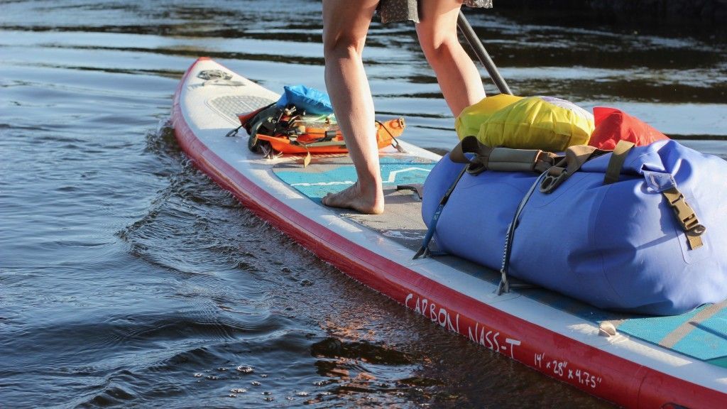 A person is standing on a paddle board in Lady Bird Lake