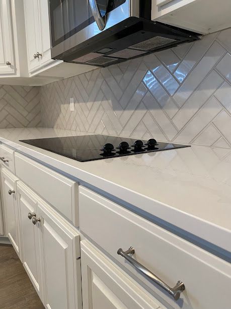 A kitchen with stainless steel appliances and white cabinets