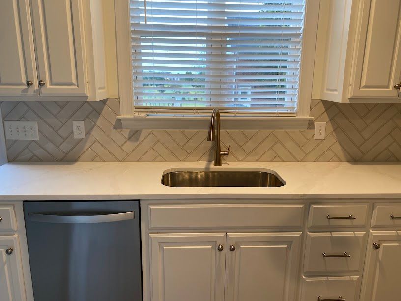 A kitchen with stainless steel appliances and white cabinets