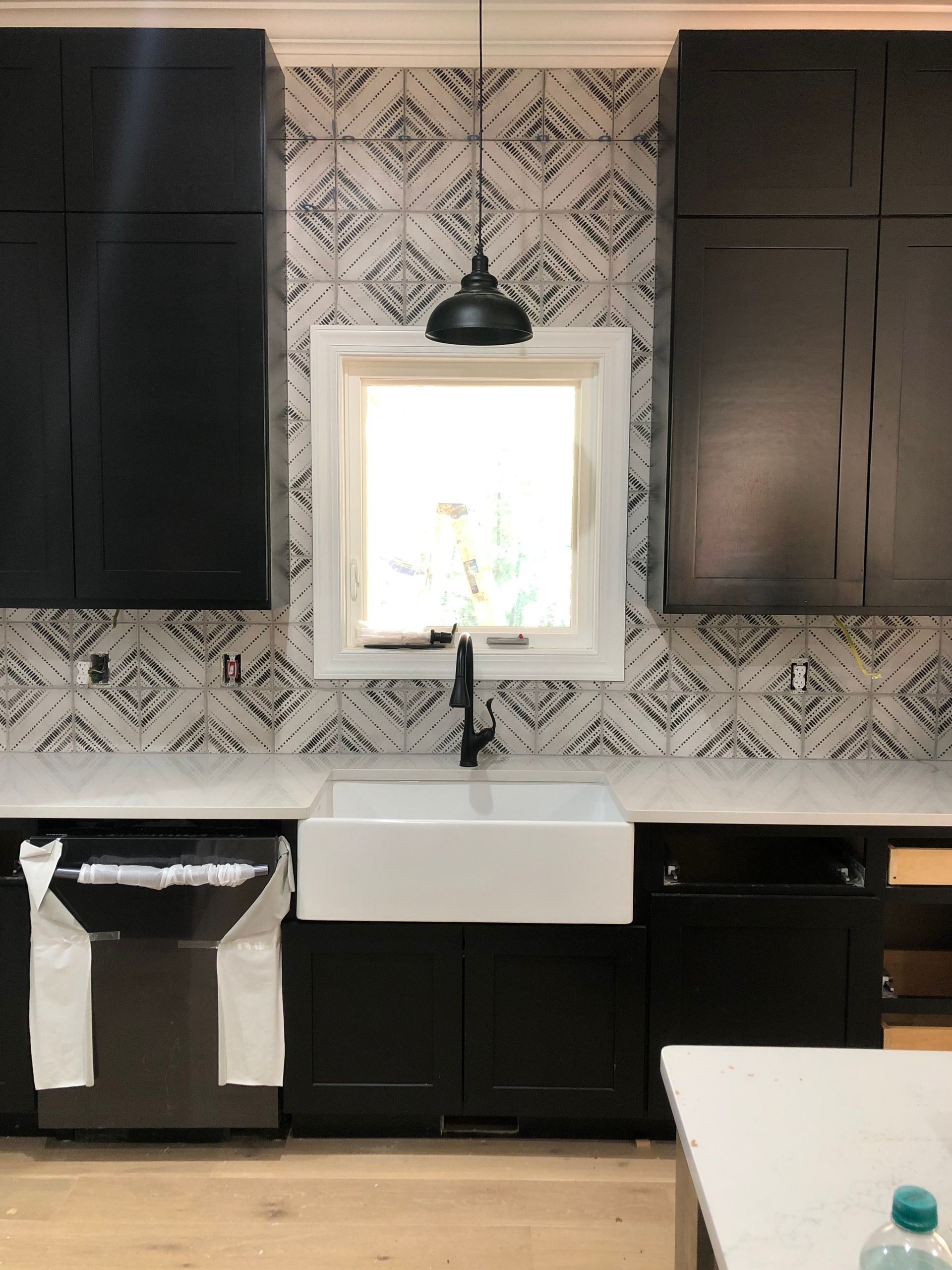 A kitchen with black cabinets and a white sink