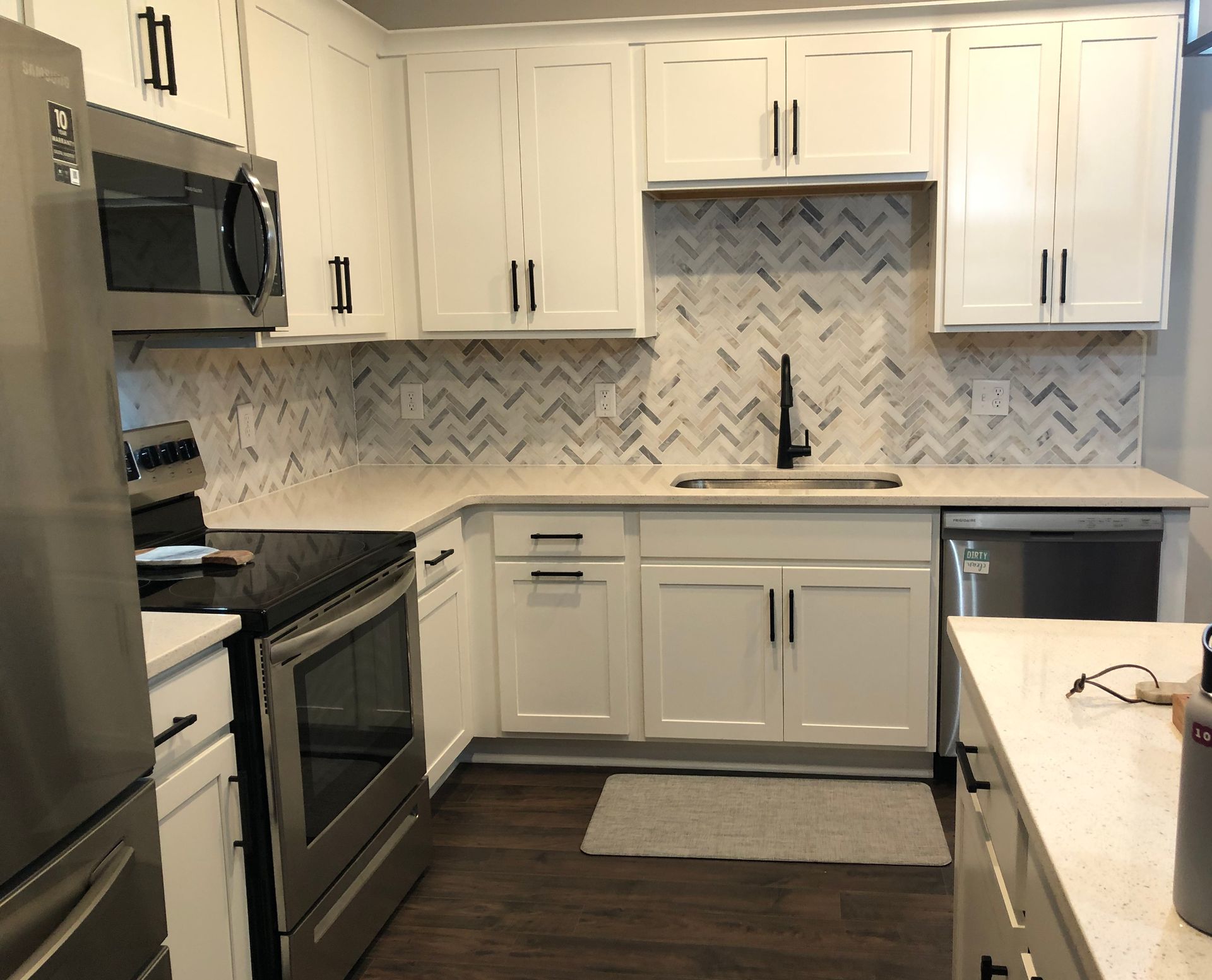 A kitchen with white cabinets and stainless steel appliances