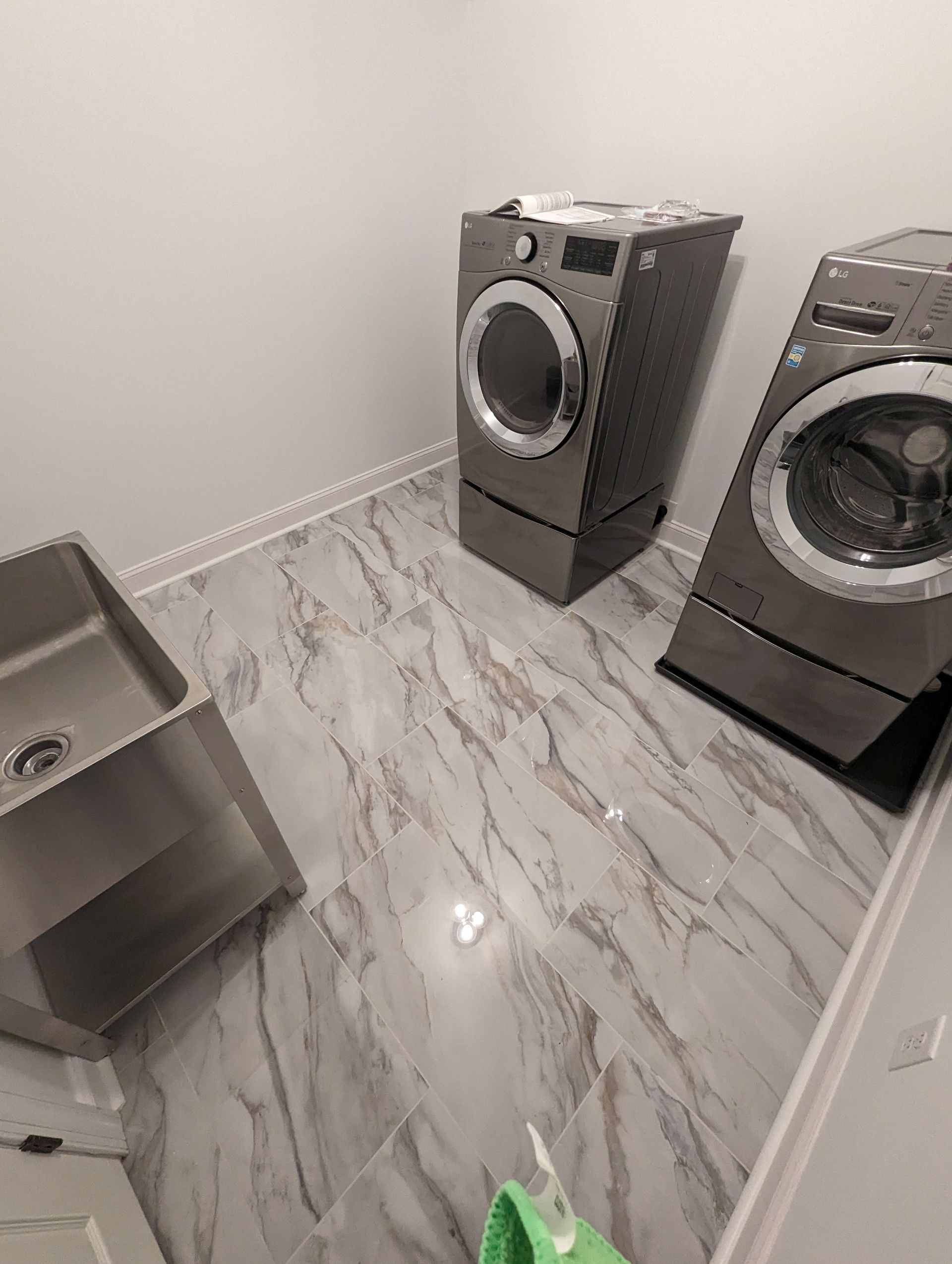 A laundry room with two washing machines and a sink.