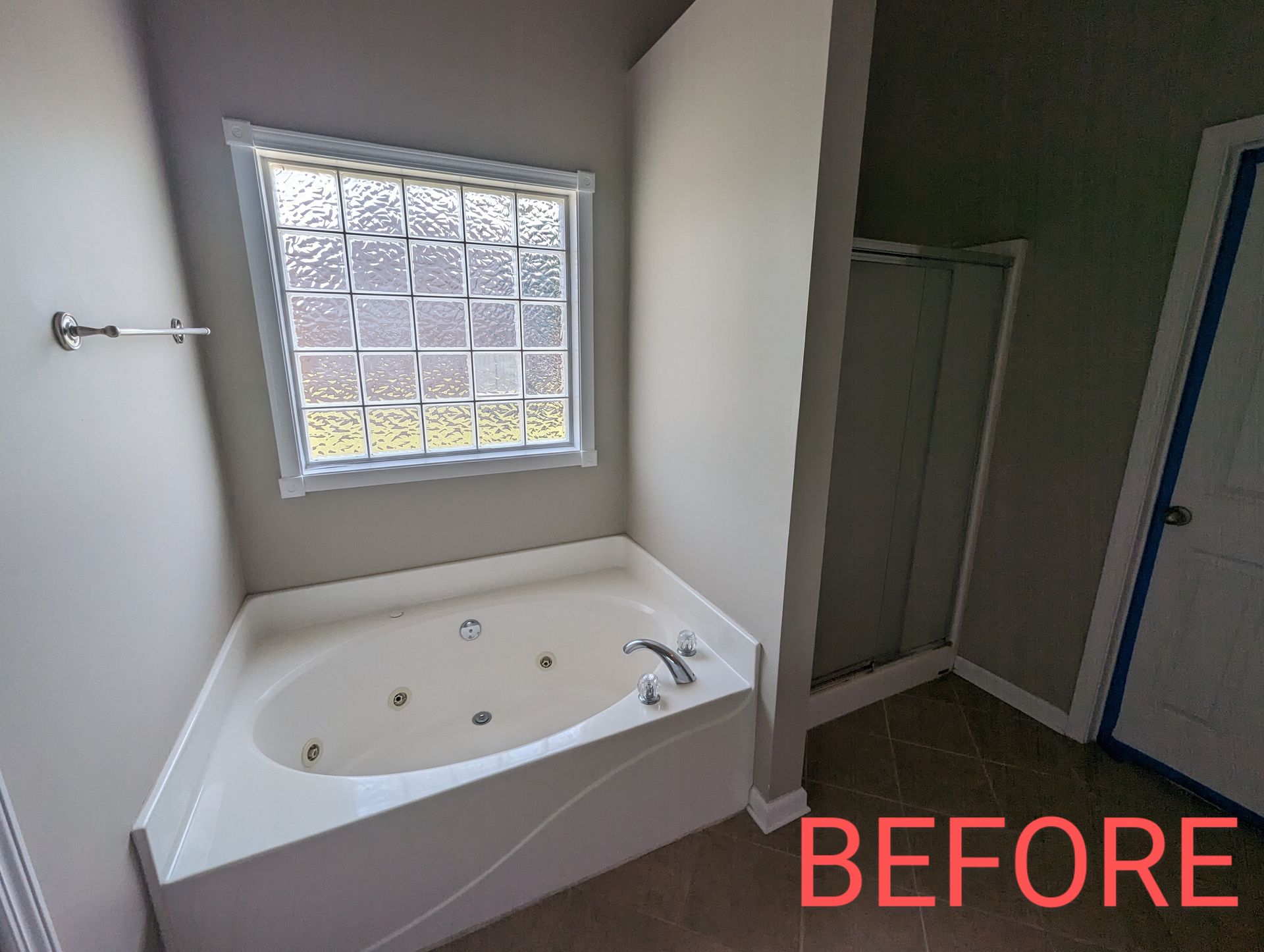 A bathroom with a jacuzzi tub and a window.