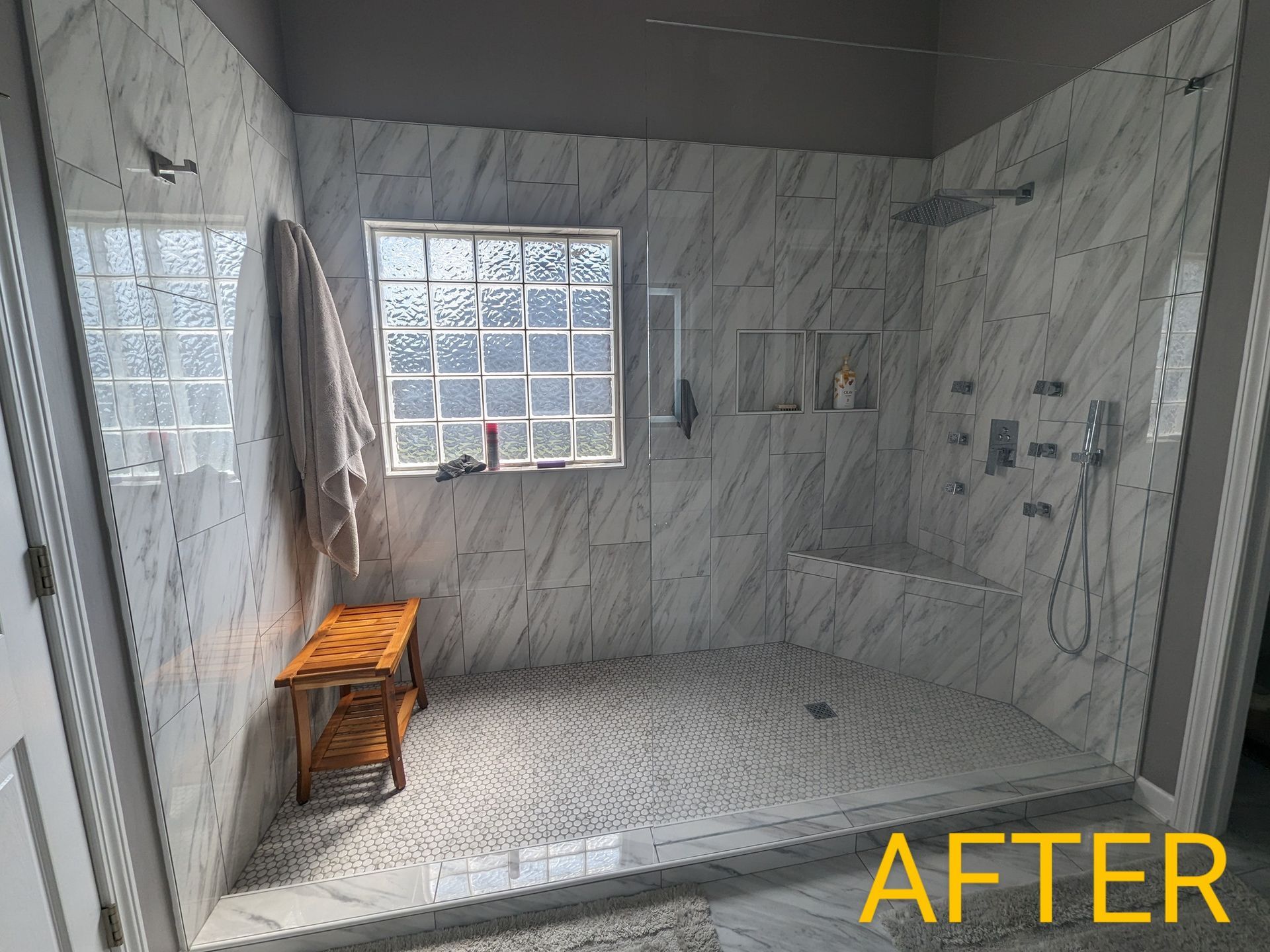 A bathroom with a walk in shower and a window.