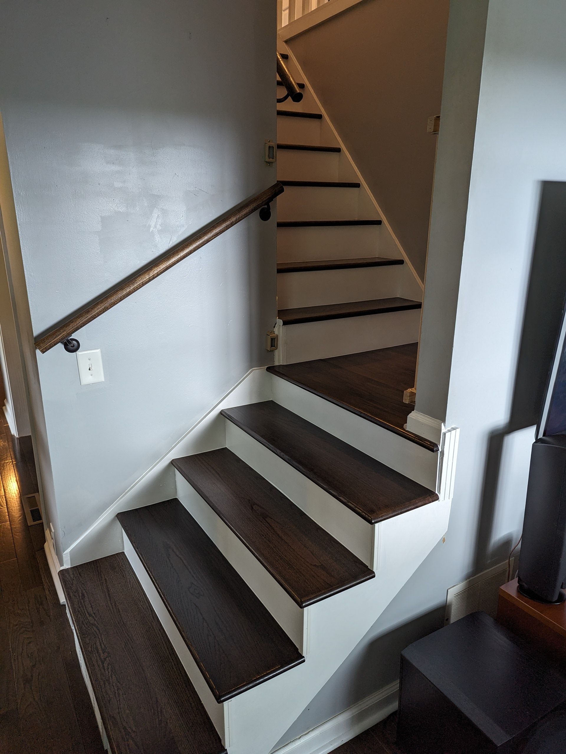 A staircase with wooden steps and a white railing in a house.