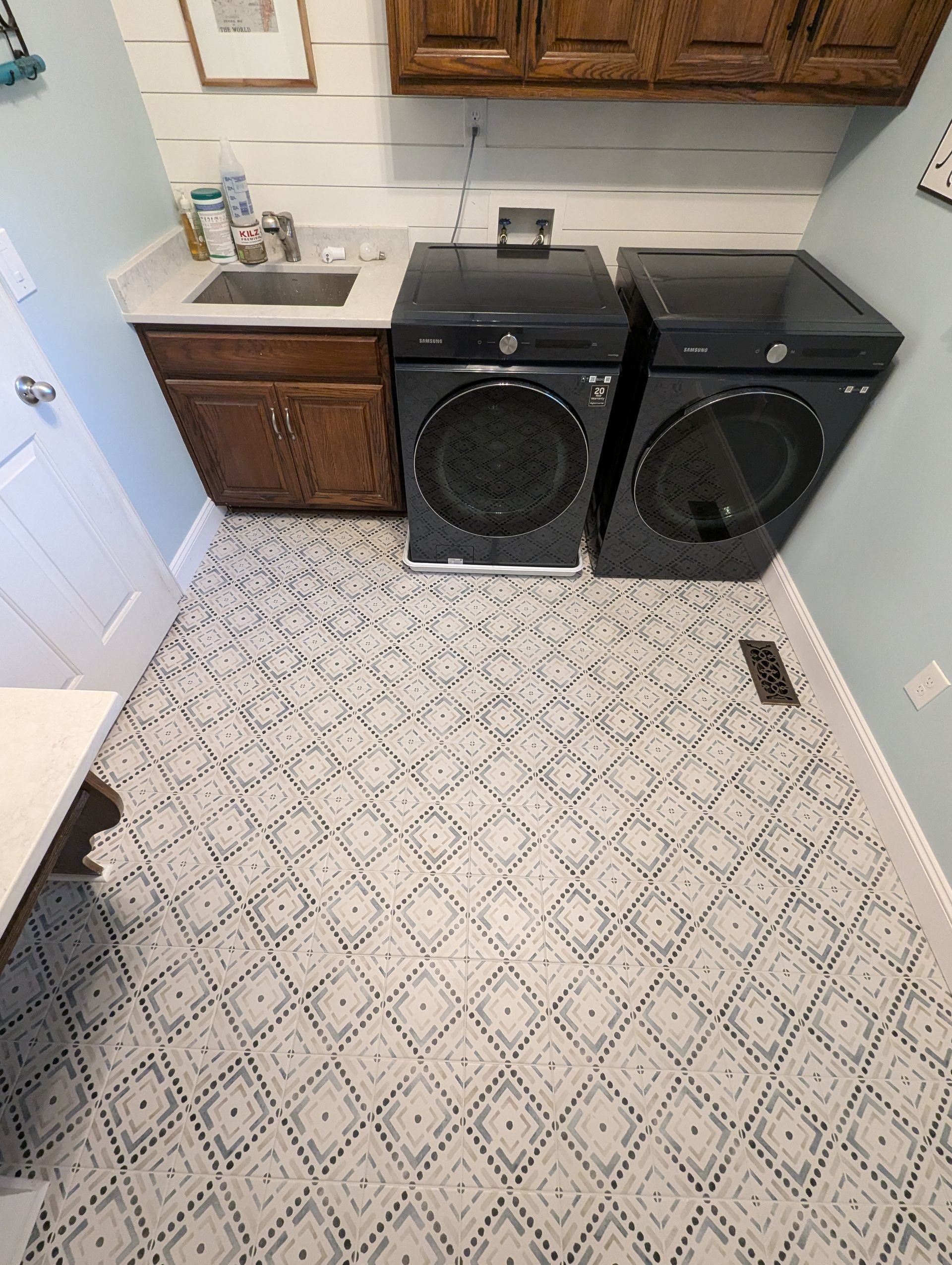 A laundry room with a washer and dryer and a sink.