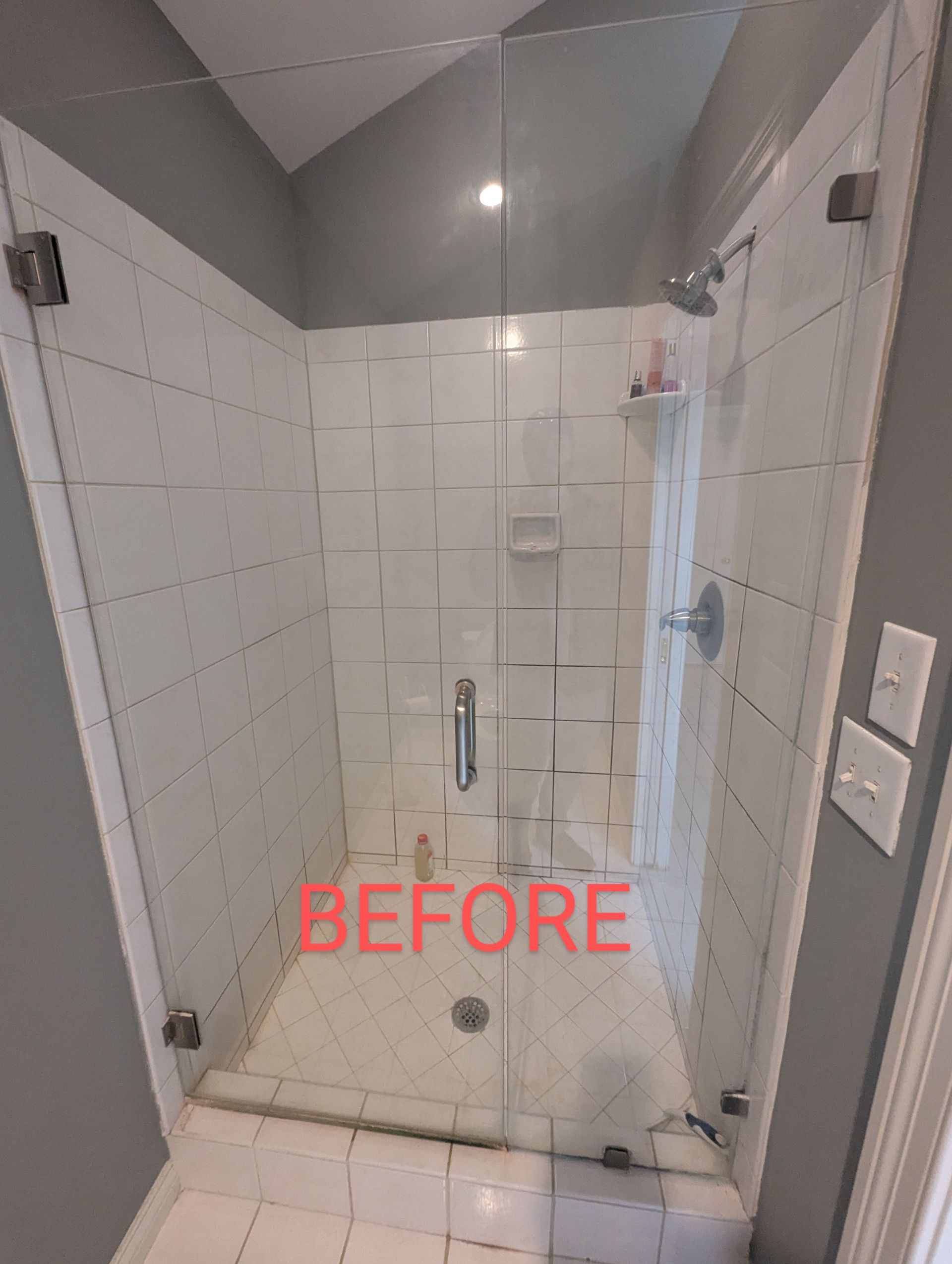 A before picture of a shower with a glass door.