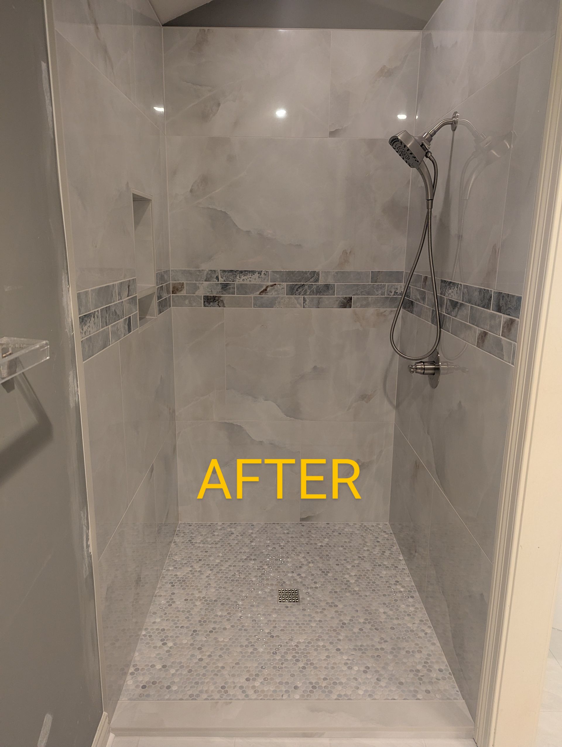 A shower stall with a shower head and a tiled floor.